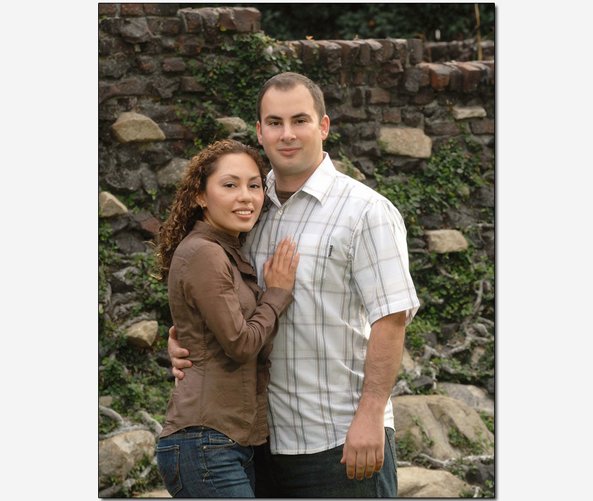 HIspanic-American couple casual pose in front of stonewall